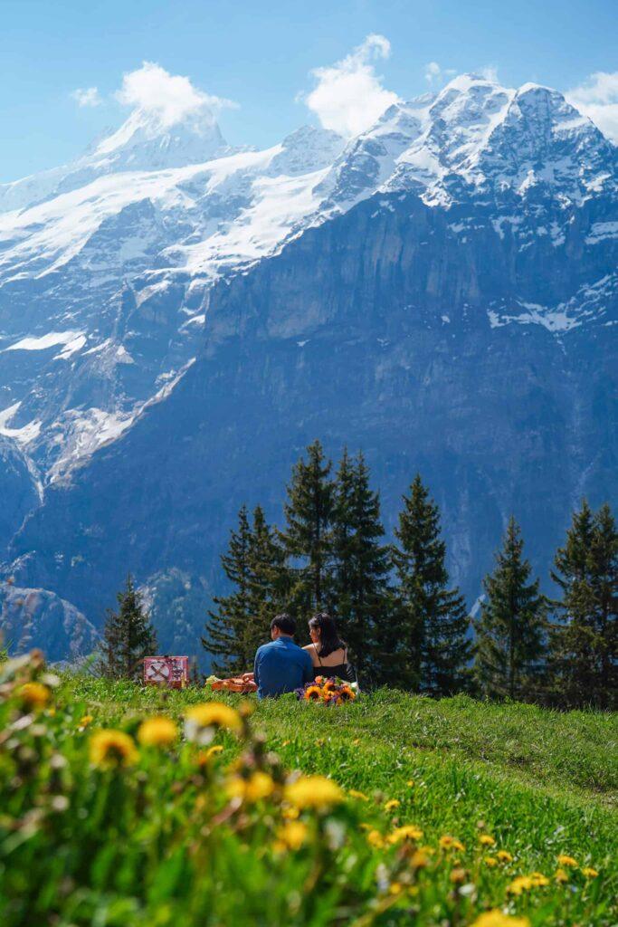 Couple relaxing after engagement in Grindelwald, with view of the Eiger mountain in the Swiss Alps