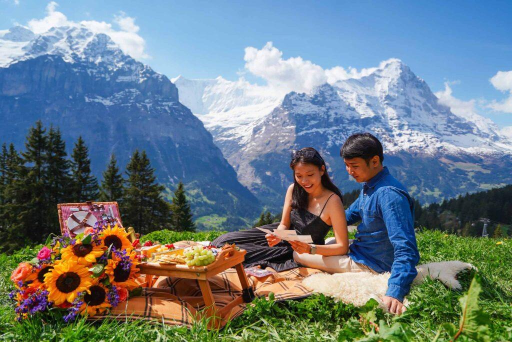 Couple enjoying luxury proposal picnic with mountain views in Switzerland