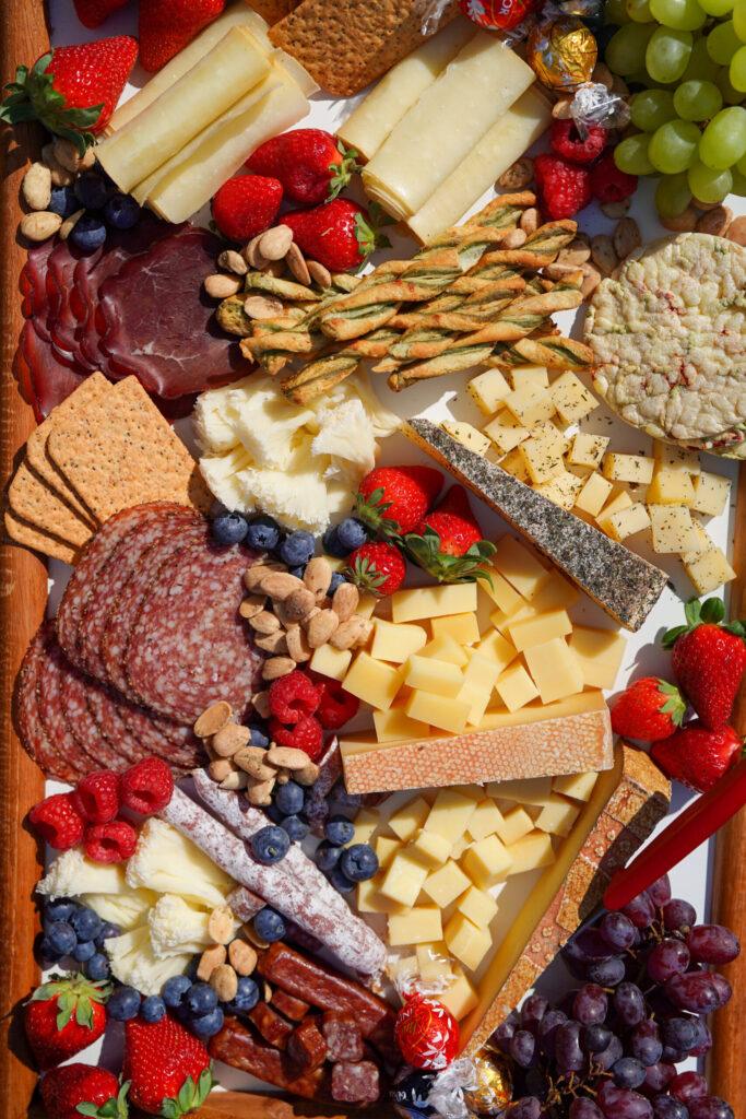 Luxury charcuterie board with Swiss cheese, fruits, and meats – picnic setup