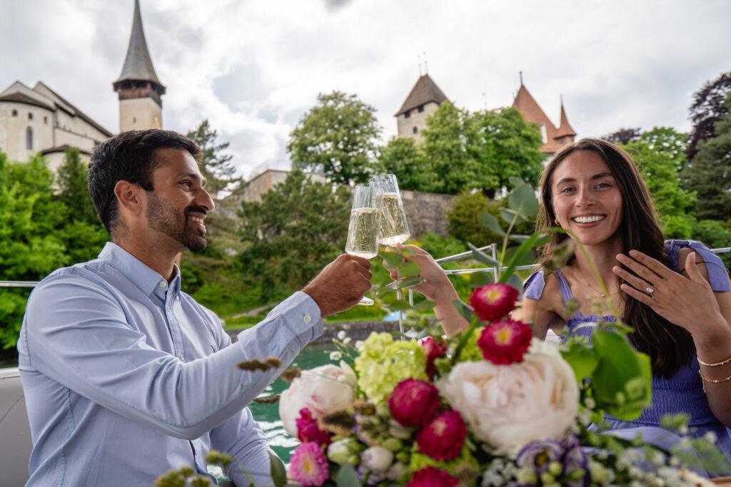 Champagne toast after boat proposal with view of Spiez Castle