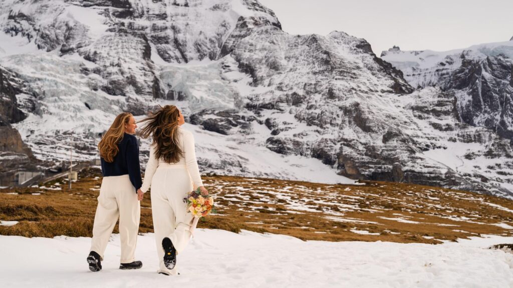 Couple enjoying a romantic winter proposal, surrounded by cliffs and Swiss Alps