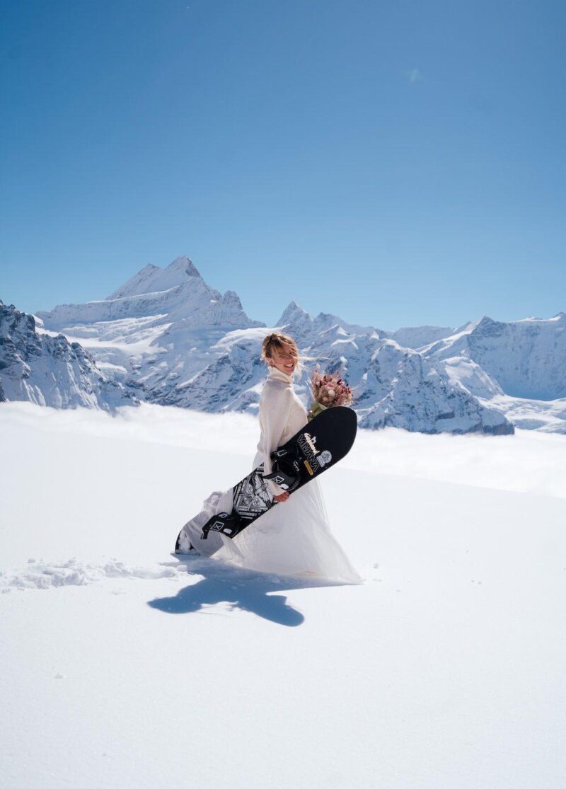 Bride walking through the snow at First, Grindelwald – winter ski elopement in the Swiss Alps