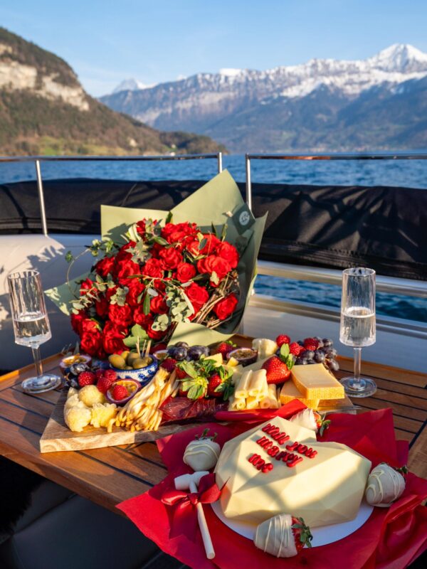 Red rose bouquet and cheese board on romantic Lake Thun boat